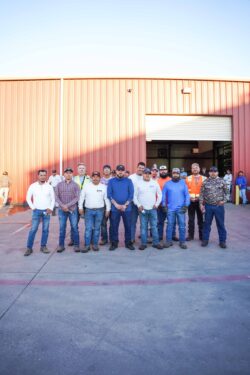 KPost Roofing team stands in front of a warehouse