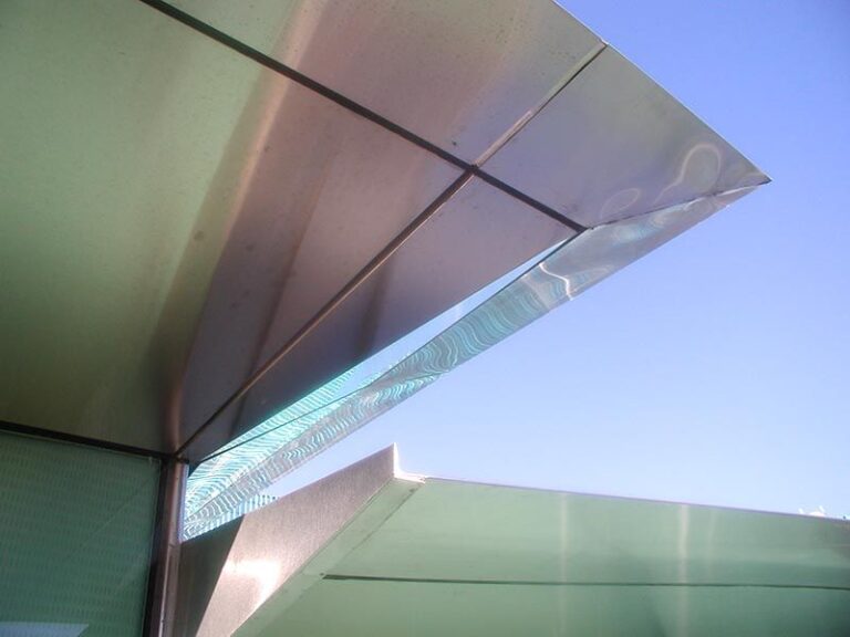 photo of underneath silver roof with blue sky background